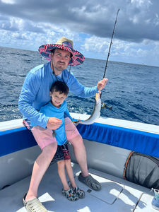 Fishing scene on boat with caught fish and fishing rod over ocean water