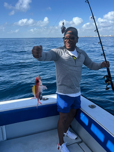 Fishing catch displayed on boat deck with fishing rod and ocean waters
