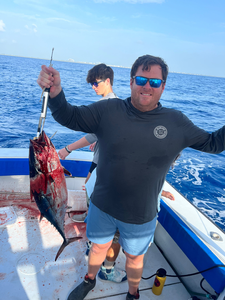 Fresh caught fish displayed on fishing boat deck over blue ocean water