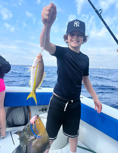 Fishing boat with yellowfin and queen triggerfish catch on deck in ocean waters