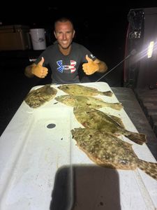 Angler holding two summer flounder and one pacific halibut in Florida