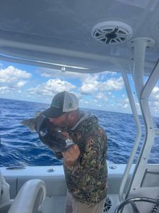 Angler kissing fish on fishing boat in Fort Myers FL waters