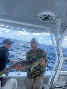 Angler holding caught fish on fishing boat in Fort Myers FL waters