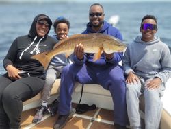 Anglers with a large redfish caught in FL