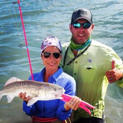 A fisherman holding a 16-inch redfish in Port Mansfield
