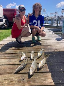 Two anglers fishing in North Carolina with three fish