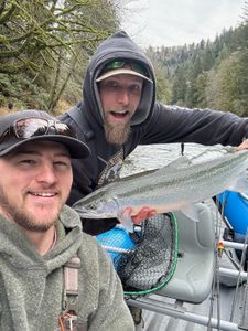 Two anglers standing in a river in Tillamook, Oregon, fishing with fishing rods.
