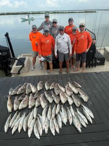 Large catch of fish displayed on wooden dock after successful fishing trip in Corpus Christi TX