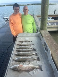 Fresh catch of redfish and speckled trout displayed on ice in cooler at Corpus Christi fishing dock