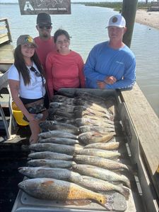 Successful fishing trip displaying catch of redfish and speckled trout on dock in Corpus Christi TX