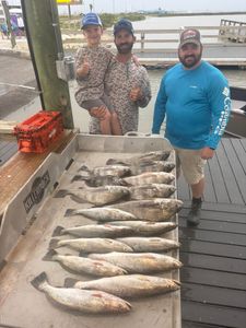 Successful fishing trip in Corpus Christi TX displaying speckled trout and black drum catch on boat deck
