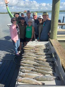 Successful speckled trout fishing trip in Corpus Christi TX with large catch displayed on dock