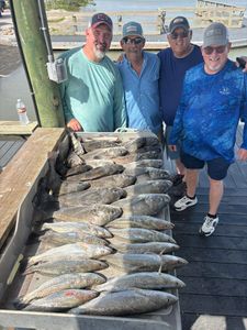 Successful speckled trout fishing trip in Corpus Christi TX with large catch displayed on dock