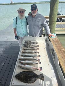 Fishing catch display showing speckled trout, southern flounder, and black drum on cleaning station in Corpus Christi TX
