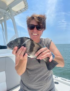 Angler posing with a 12-inch black drum fish in Mount Pleasant