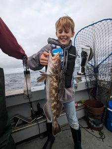 Fisherman posing with lingcod catch in Reedsport