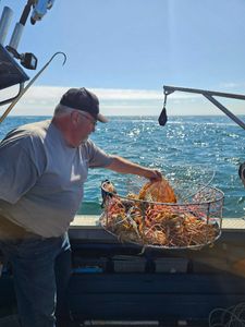 Crab trap being handled on fishing boat deck in Reedsport OR waters