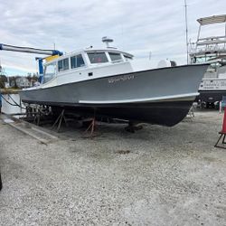 White fishing boat with dark blue hull on dry dock in Baltimore MD boatyard