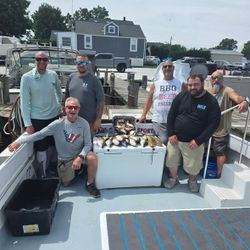 Fishing charter group displaying fresh catch in cooler on boat deck at Baltimore MD marina