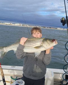 Angler proudly holding a white bass fish in NJ