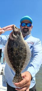 Angler catching a summer flounder fish in TX