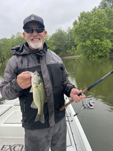 A trophy largemouth bass landed after a battle in the partly cloudy skies!