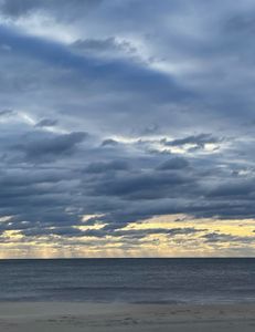 Dramatic skies meet calm seas.