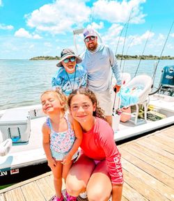 Fishing boat docked at marina in Corpus Christi TX with calm water and cloudy sky