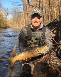 A fisherman holding a large rainbow trout in New Hartford