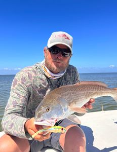 A fisherman holding a 19-inch fish at St Marks