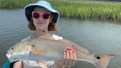 A fisherman holding a large redfish caught in SC