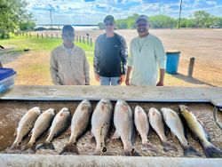 Successful redfish and channel catfish fishing trip in Elmendorf TX with multiple fish displayed on cleaning table