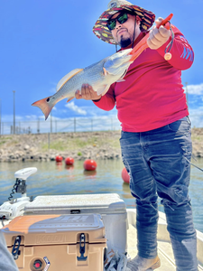 Angler holding a 15-inch redfish in Elmendorf