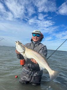 An angler proudly holding a 24-inch fish in Rockport