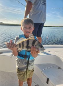A fisherman holding a black drum fish in GA