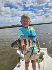 A fisherman holding a black drum fish in GA