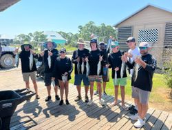 A group of 9 people enjoy fishing in the waters of Gulf Shores