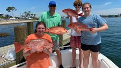 Four people fishing in the Gulf Shores with 4 big fish