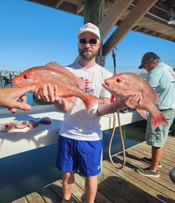 Two red snapper caught during Gulf Shores Alabama fishing trip displayed on boat deck