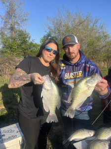 Two anglers displaying freshly caught fish in North East PA with trees in background