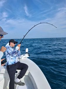 Deep sea fishing with bent rod showing active catch on charter boat in Port Orange FL