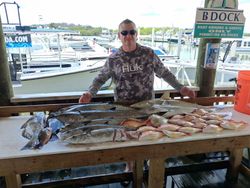 Large fishing catch displayed on cleaning table at Port Orange FL marina with various fish species