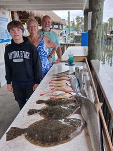 Fishing charter catch display featuring Southern Flounder, Summer Flounder, and Picked Dogfish on cleaning table at Port Orange FL marina