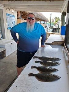 Four flounder fish laid out on cleaning station table at Port Orange FL fishing dock