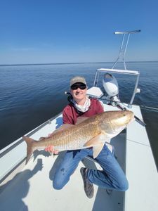 Fisherman standing in water holding fishing rod in Panacea