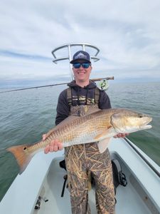 A fisherman holding a redfish in Panacea