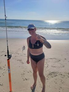 Surf fishing scene on Melbourne FL beach with fishing rod and small catch