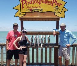 3 people fishing for a group of 5 fish in Port Isabel