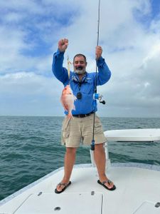 Angler holding a 13-inch fish in Port Isabel