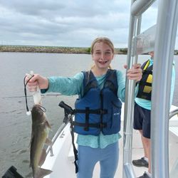 Beaming with a lively channel catfish—awesome job!